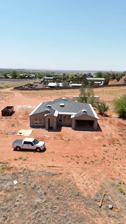 5 Bed / 3 Bath — Shingles staged over underlayment; stucco base applied